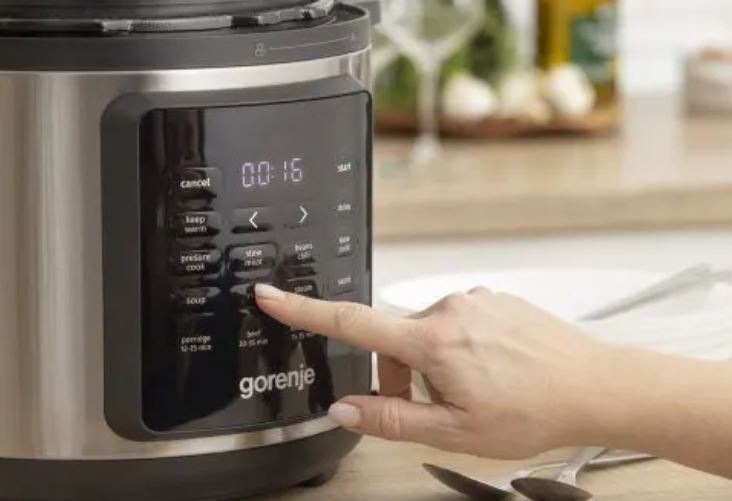 Multifunkční hrnec Gorenje GMC6SBK stříbrný ruka nastavuje pokrm na displeji hrnce Gorenje GMC6SBK