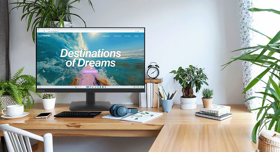 Monitor Lenovo L27-4e černý Moderní domácí kancelář s velkým monitorem zobrazujícím „Destinace snů“. Obklopená rostlinami, knihami a sluchátky, vytváří klidné pracovní prostředí.