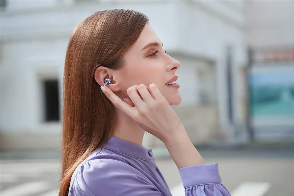 Žena na ulici se dotýká sluchátka HONOR CHOICE Earbuds Clip