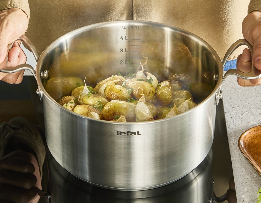 Muž připravuje přílohu k hlavnímu chodu v hrnci Tefal.