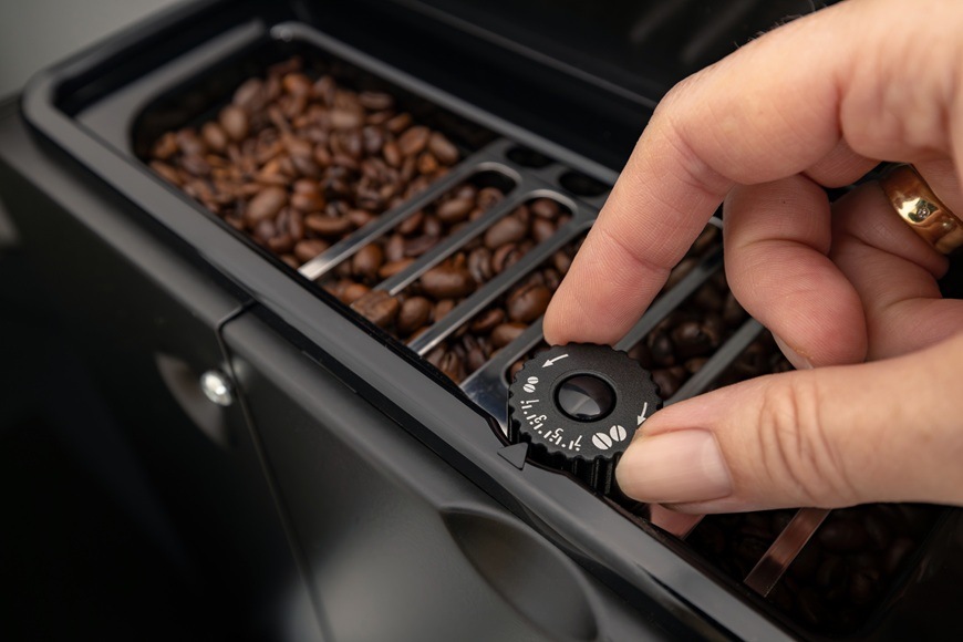 Espresso Gorenje G800 CM4G8BG černá Na obrázku je ruka nastavující stupeň intenzity kávy.