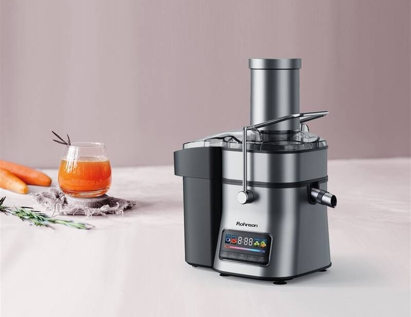 Odšťavňovač Rohnson R-4010 1 500 W černý/stříbrný Odšťavňovač Rohnson R-4010 na kuchyňské lince připravuje čerstvou mrkvovou šťávu do sklenice.