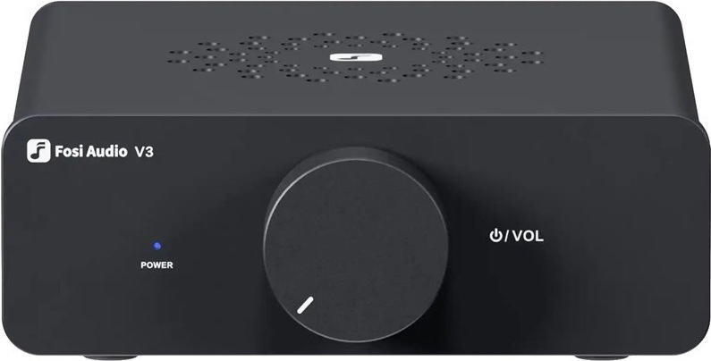Na obrázku je stolní zesilovač Fosi Audio V3-48V v černém provedení, zachycený zepředu. Má kompaktní kovové tělo s čistým minimalistickým vzhledem a na přední straně dominuje velký kulatý otočný ovladač hlasitosti. Vlevo je malé modré světlo signalizující zapnutí a vpravo vedle ovladače nápis pro ovládání napájení a hlasitosti. Na horní straně jsou drobné větrací otvory.
