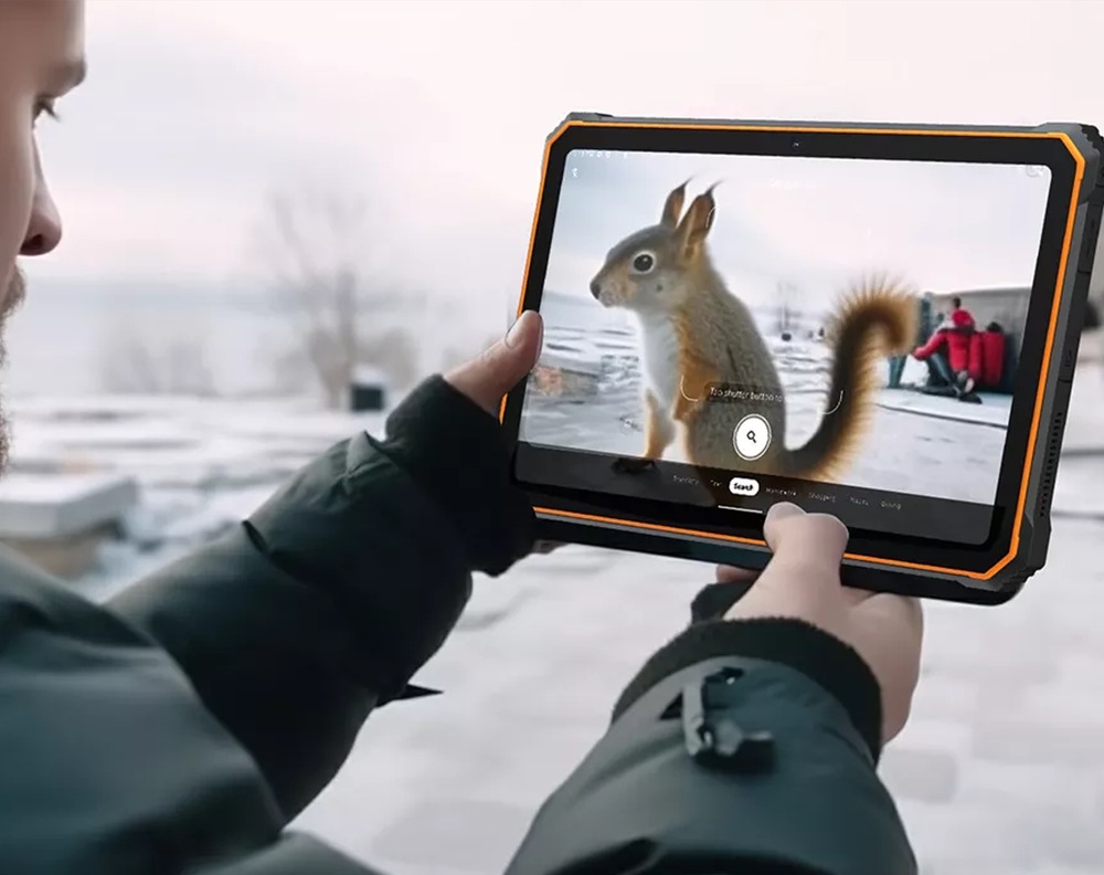 Tablet Blackview Active 8 Pro používaný venku v zimním prostředí, uživatel drží tablet v rukavicích a sleduje obsah na displeji