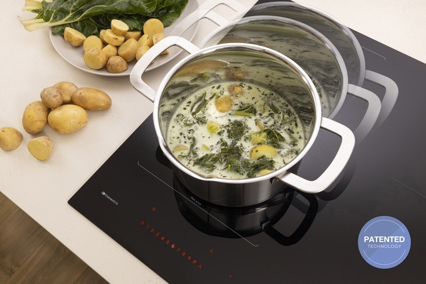 Indukční varná deska Gorenje G800 GI6443BSCWF černá Na varné desce Gorenje GI6443BSCWF je položen hrnec a v něm se vaří smetanová polévka.