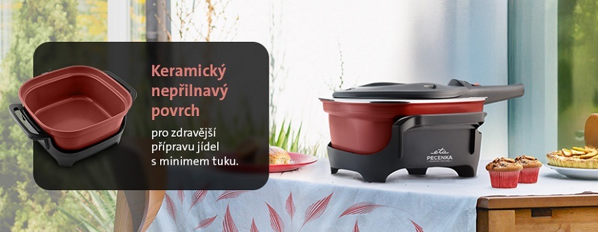 Elektrický pečicí hrnec ETA PEČENKA s červeným keramickým nepřilnavým povrchem pro zdravější vaření s minimem tuku postavený na jídelním stole s upečeným koláčem a muffiny