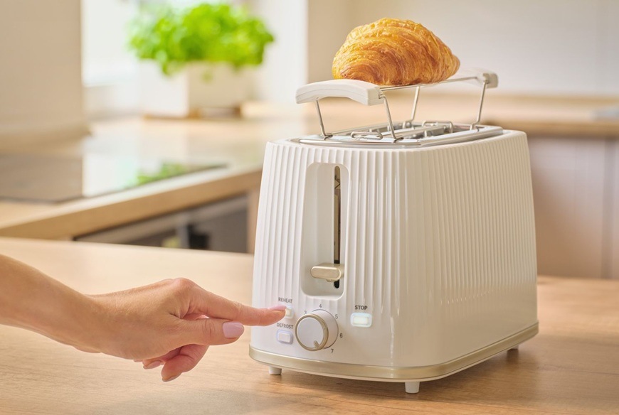 Topinkovač Sencor STS 7510WH bílý Žena nastavuje na topinkovači funkci ohřevu. V pozadí je moderní kuchyně.