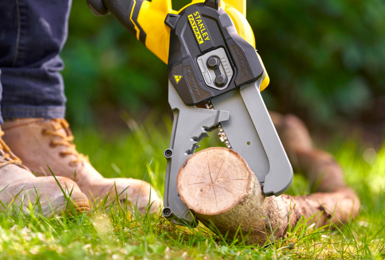 Stanley FatMax SFMCPS515M1-QW při řezání menšího kmene na zahradě při práci jednou rukou