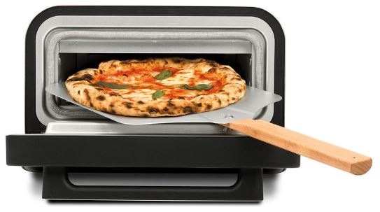 Pizza trouba s otevřenými dvířky a pizza lopatou, na které leží čerstvě upečená pizza s křupavým okrajem.
