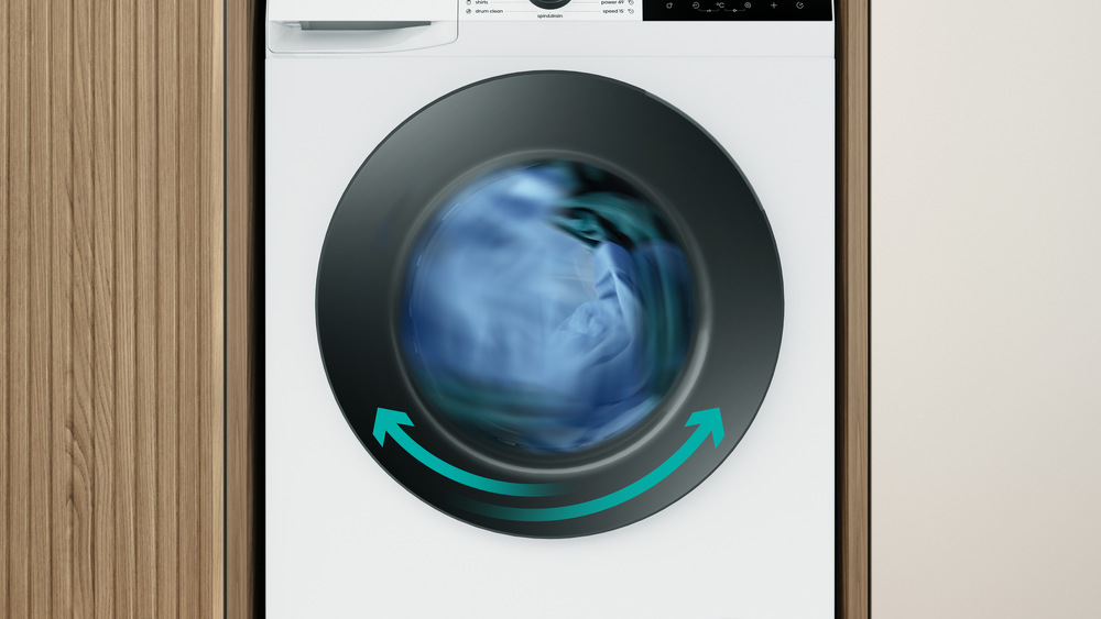 pračka se sušičkou Gorenje WDG2PS954A1D2 s prádlem uvnitř a obousměrnými šipkami 