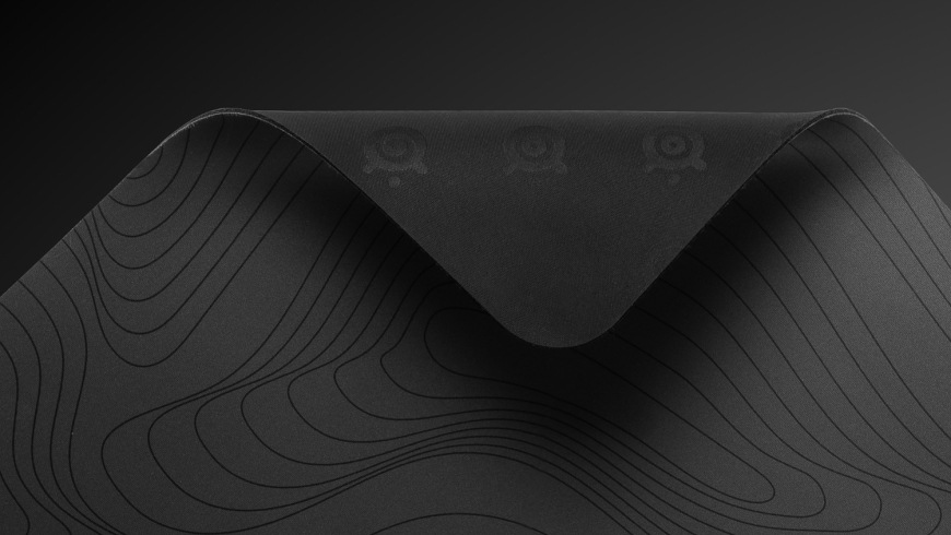 Podložka pod myš SteelSeries QcK Large, Topographic černá Odklopený roh podložky QcK Topographic odhalující gumovou spodní stranu