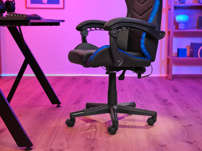 Detail na ergonomické tvarování herní židle, její podsvícení podél konstrukce a s detailem na univerzální pojezdová kolečka.