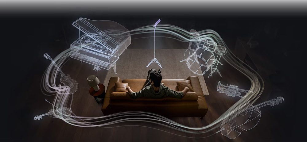 Muž sedící na pohovce si vychutnává prostorový zvuk sluchátek Samsung Galaxy Buds4