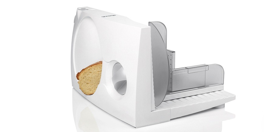 Zadní pohled na bílý kráječ Gorenje R401W, kde se právě krájí pečivo.