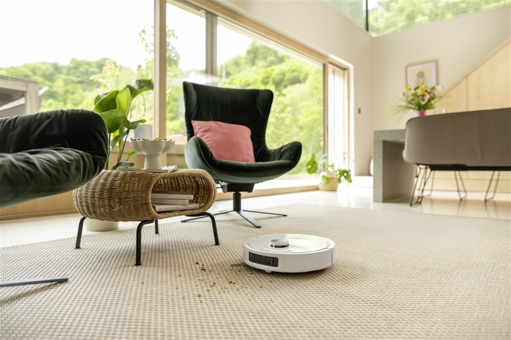 Robotický vysavač Kärcher RVM 4 Comfort bílý Kärcher RVM 4 Comfort při vysávání drobných nečistot z koberce v moderním obývacím pokoji