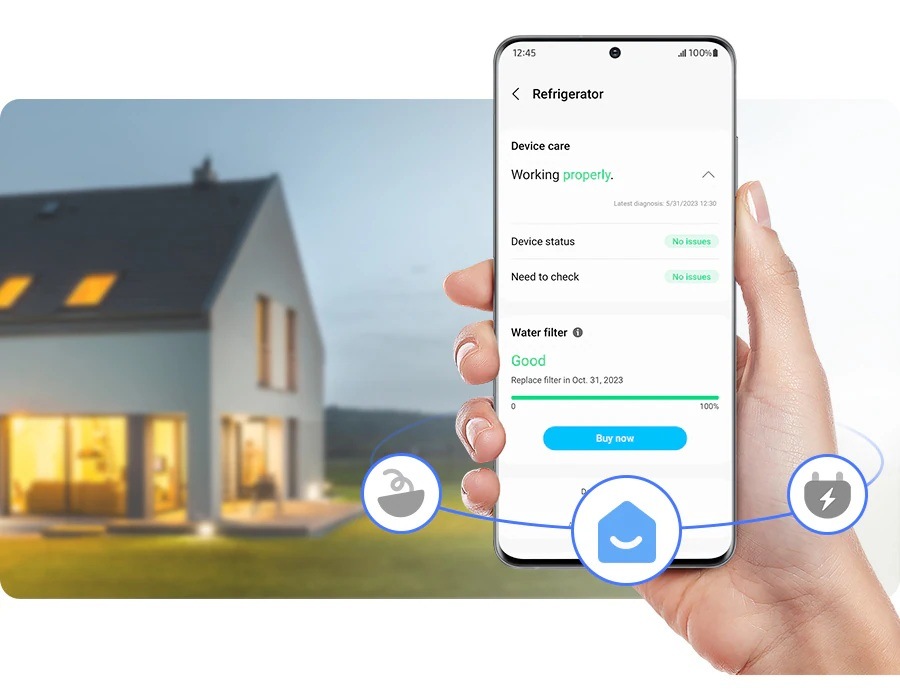 Ruka drží mobilní telefon s aplikací SmartThings Home, na pozadí je dům s rozsvícenými světly