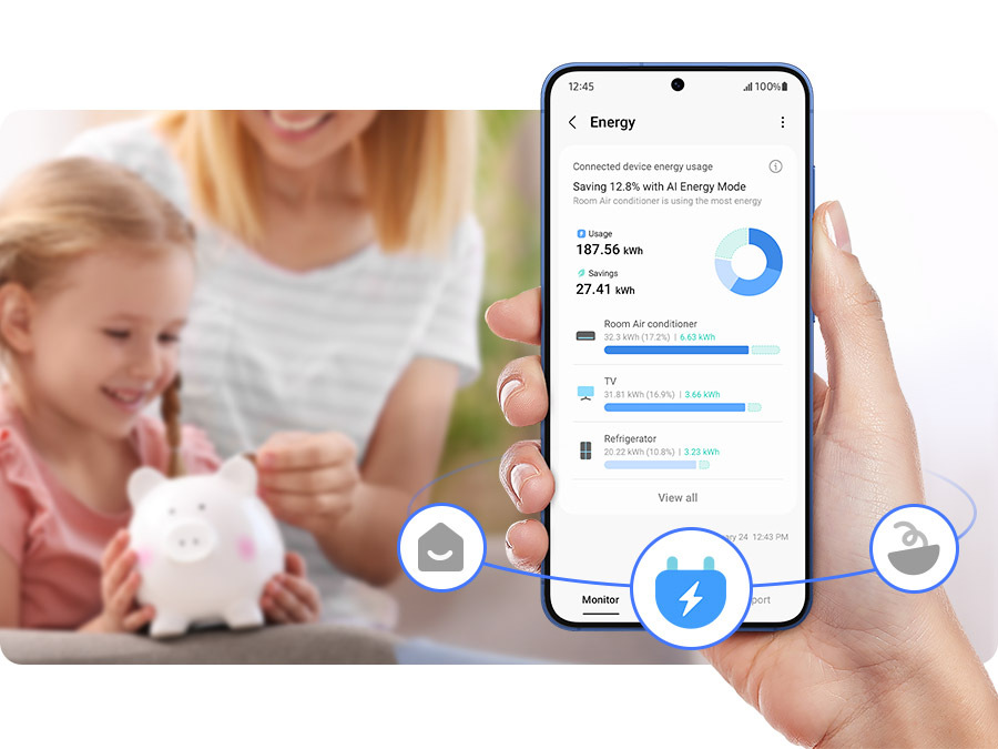 Americká lednice Samsung RM70F63NEREO nerez/ocel Ruka drží mobilní telefon s aplikací SmartThings Energy, na pozadí je žena s dítětem, které drží v rukou kasičku ve tvaru prasátka