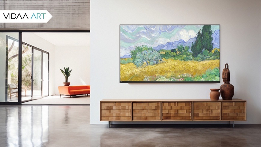 Televize JVC LT-65VDQ9435 Televize JVC visicí na zdi prostorného industriálního domu, promítající obraz krajiny Vincenta van Gogha – Pšeničné pole s cipřiši pomocí funkce VIDAA ART