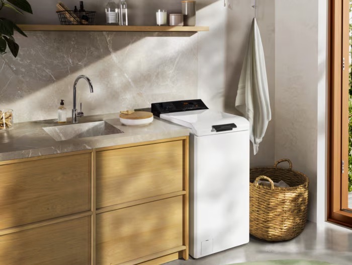 Pračka AEG LTE6K273C řady 6000 ProSense vedle linky s dřezem.