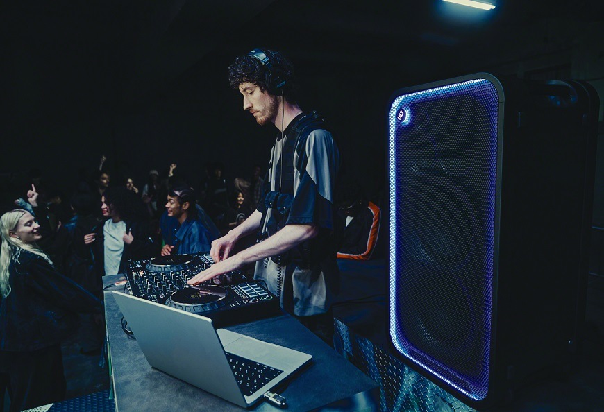 Party reproduktor Sony ULT TOWER MAX při použití během DJ vystoupení s výrazným světelným efektem