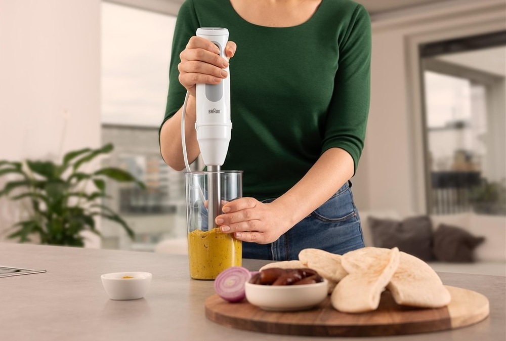 Ponorný mixér Braun MultiQuick 5 MQ50.236M bílý Žena v zeleném svetru připravuje pomocí tyčového mixéru Braun MultiQuick 5 hummus