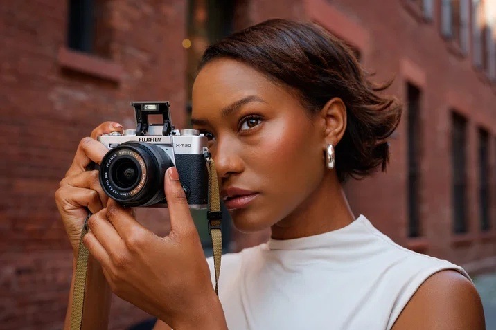 Žena fotografující pomocí fotoaparátu Fujifilm X-T30 III s automatickým bleskem