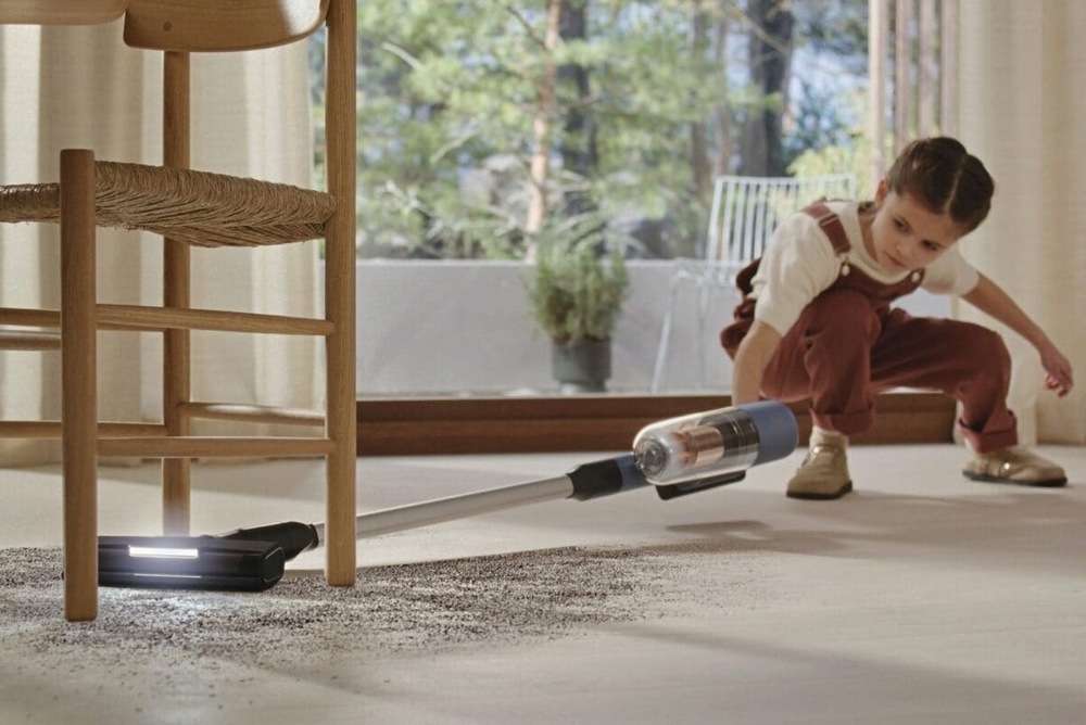 Tyčový vysavač Electrolux 700 Hygienic EP72H21WET modrý Holčička vysává nepořádek pod židlý s pomocí vysavače Electrolux.