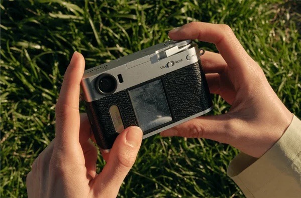 Digitální fotoaparát Fujifilm X half černý Zadní pohled na fotoaparát Fujifilm X half držený v rukou s viditelným displejem a ovládacími prvky