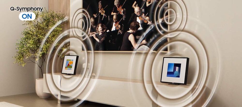 Reproduktory Samsung HW-LS60D, Music Frame (2 ks) černé Dva reproduktory Samsung HW-LS60D, Music Frame stojí na televizním stolku v obývacím pokoji, kolem reproduktorů se šíří kroužky, které znázorňují prostorový zvuk, nad reproduktory je televize Samsung, v levém horním rohu je nápis Q-Symphony ON