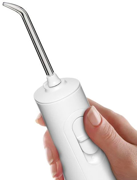 Ruka drží ústní sprchu Waterpik WF26EU s nasazenou tryskou a ovládáním tlaku