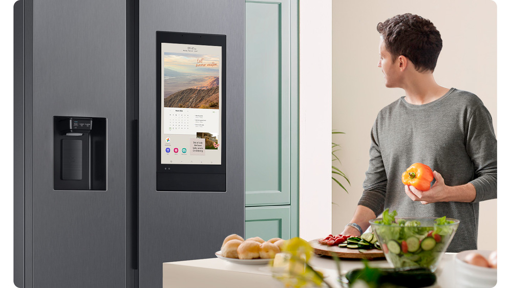 Muž sledující u vaření displej Family Hub na lednici Samsung RS6HDG883EB1EF