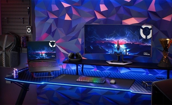 Notebook Lenovo Legion Pro 7 16IAX10H + Game Pass předplatné na 3 měsíce černý Herní prostor s velkým monitorem a notebookem, na kterém se zobrazuje městská krajina v bouřce.
