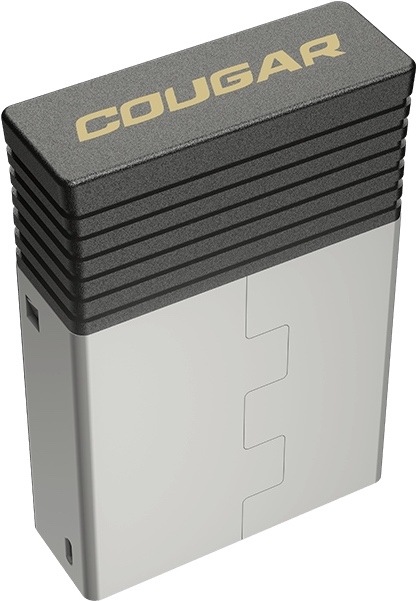 Na obrázku je příslušenství k myši Cougar Revenger PRO 4K, bezdrátový USB přijímač. Má hranaté obdélníkové tělo ve stříbrno-černém provedení. Horní černá část je vroubkovaná a nese zlatý nápis Cougar. Na boku jsou vidět malé konektory nebo otvory pro připojení. Zařízení působí jako kompaktní stolní modul k bezdrátové herní myši.