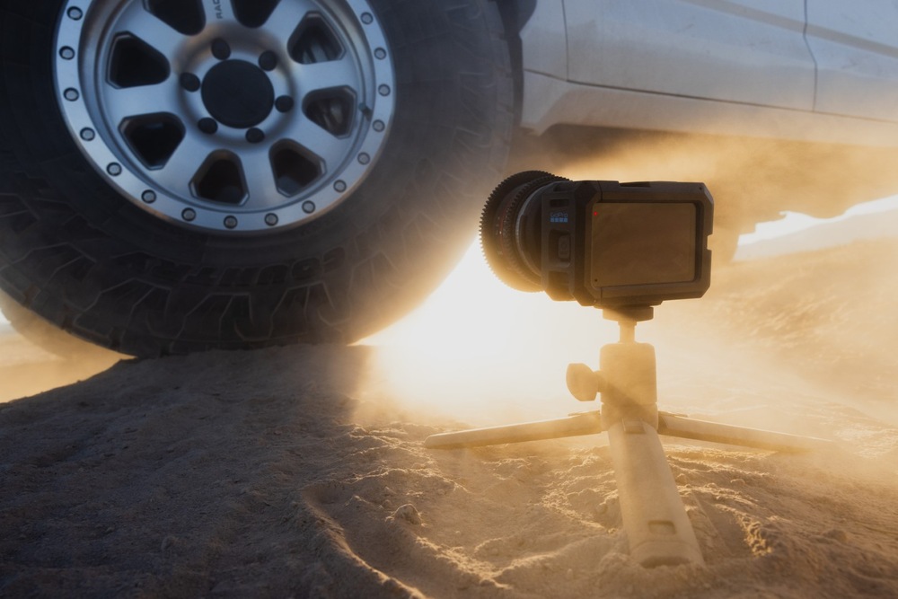 Kamera GoPro MISSION 1 PRO ILS na malém stativu vedle terénního automobilu