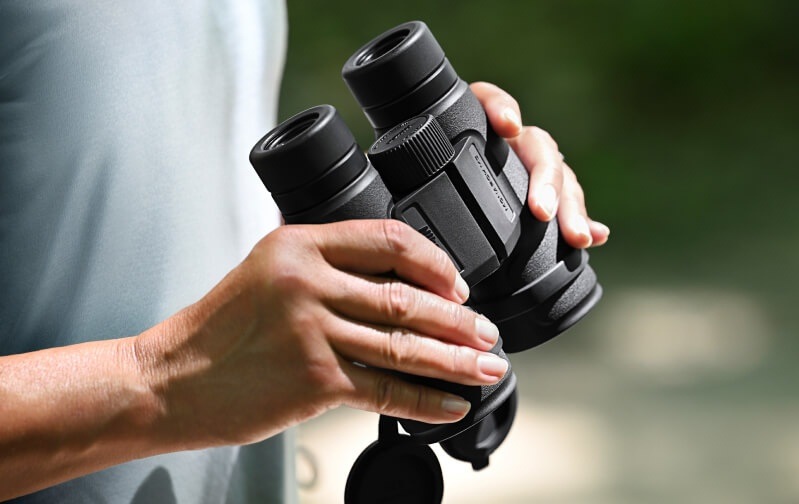 Detail dalekohledu Monarch M5 10×50 v rukou pozorovatele