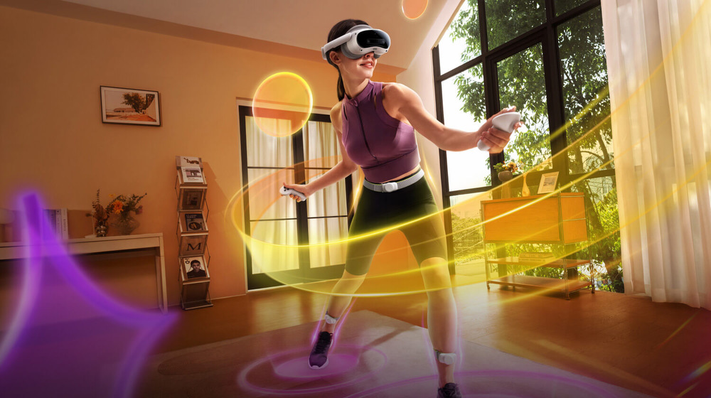 Snímač pohybu PICO Motion Tracker bílé Žena s VR headsetem si hraje v sluncem zalité místnosti, obklopená dynamickými víry žlutého a fialového světla, které vyjadřují vzrušení a pohyb.