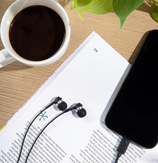 Sluchátka Sennheiser CX80U černá Na knize položená sluchátka Sennheiser CX80U a smartphone