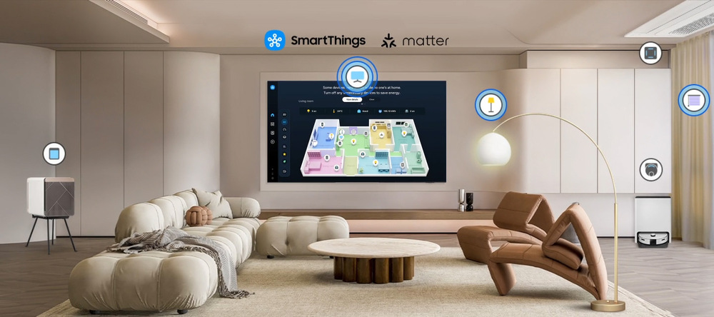 Samsung QE77S95F Aplikace SmartThings na obrazovce televize Samsung v obývacím pokoji, v místnosti jsou další chytrá zařízení (vysavač, reproduktor aj.) označená symbolem, která jsou s aplikací propojená