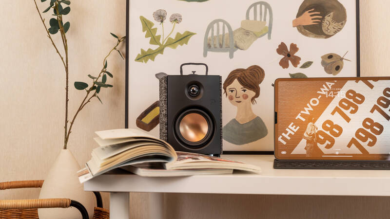 Reproduktory Swan OS-10 (2 ks) černé Zátiší s reproduktorem Swan OS-10 na bílém stole u knih a tabletu.