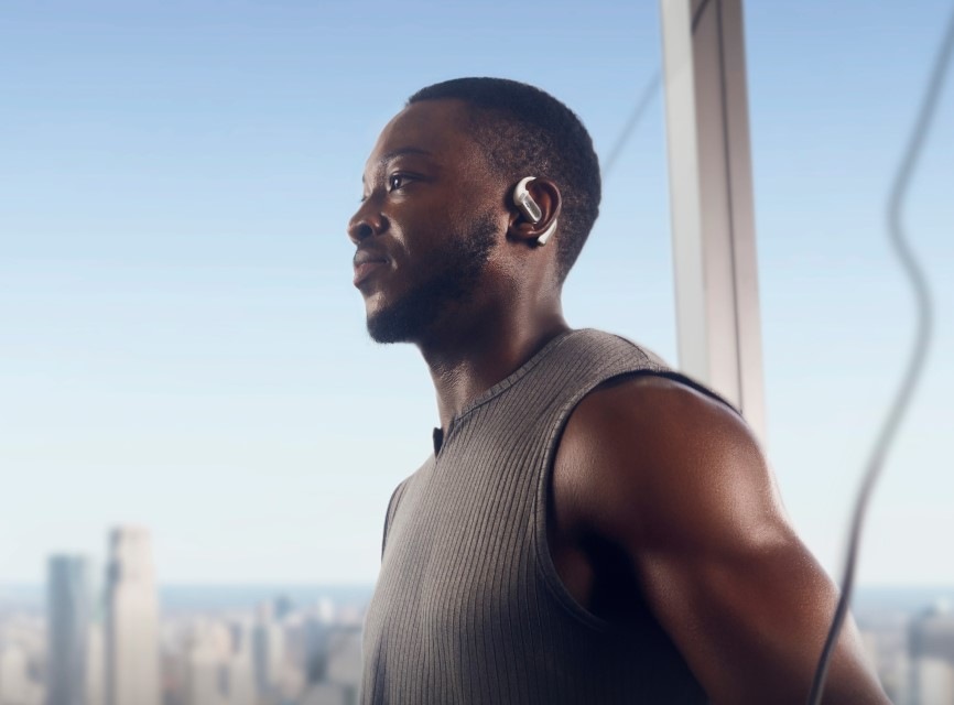 Sluchátka Shokz OpenFit PRO, Bluetooth bílá Posilující muž má na uších sluchátka OpenFit PRO