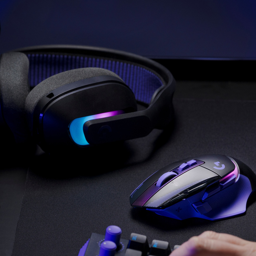 Myš Logitech G502 X Plus na podložce vedle headsetu a klávesnice v herní sestavě
