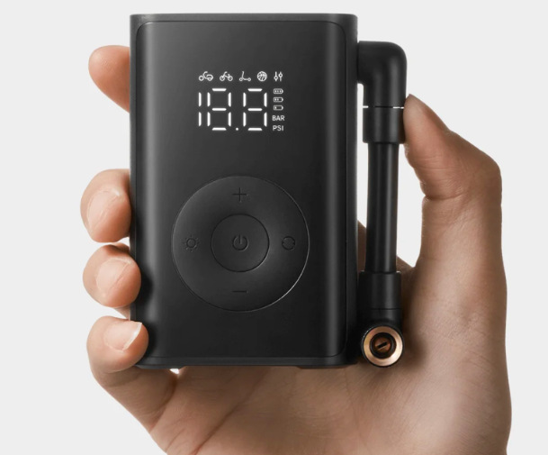Kompresor Xiaomi Mijia Compact Portable držený v ruce se zapnutým displejem a ovládáním