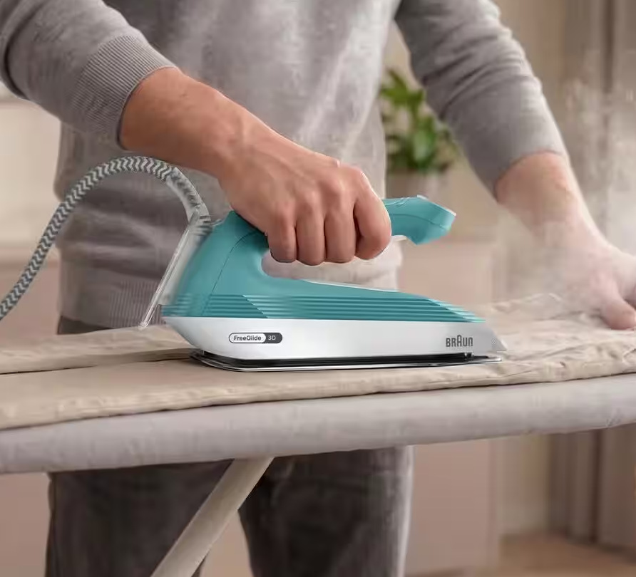 Žehlicí systém Braun Upstyle 2 IS2745.BL modrý Muž si žehlí kalhoty parní žehličkou Braun IS2735.GR Upstyle 2