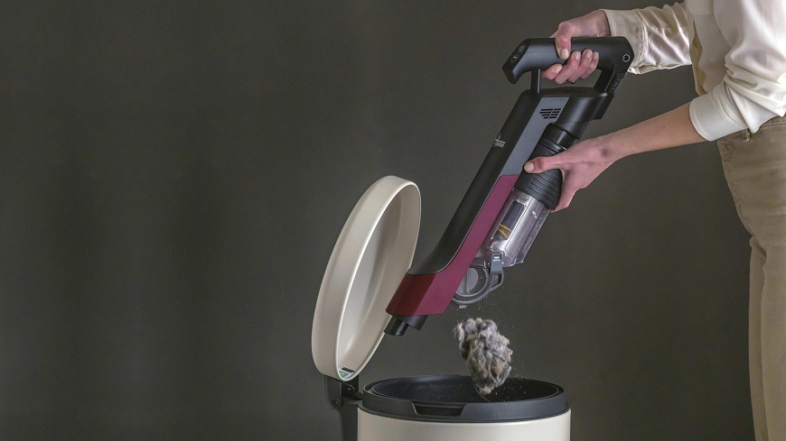 Tyčový vysavač Hoover HF210HXP 011 černý osoba sype obsah nádoby na nečistoty do koše