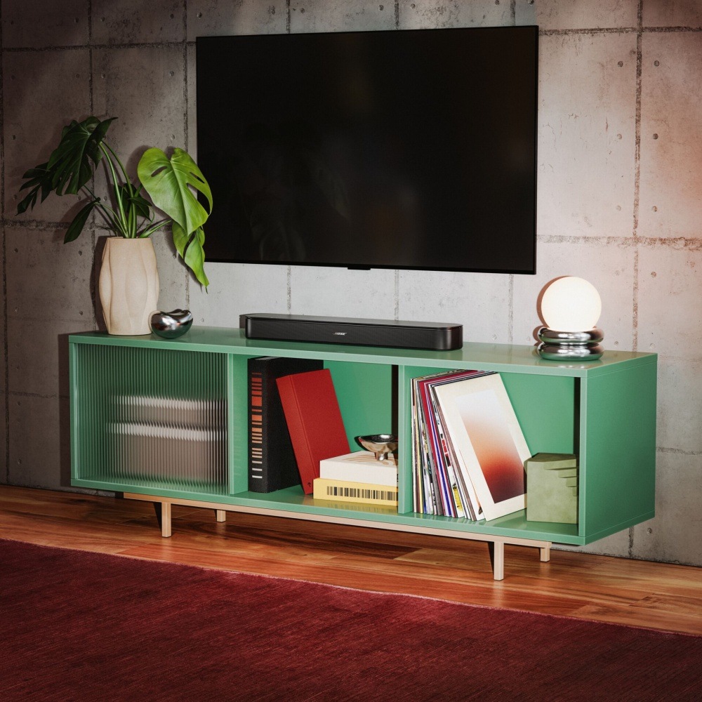 Soundbar Bose TV Speaker 2nd.Gen. černý Soundbar Bose TV Speaker pod televizí na zeleném televizním stolku v obývacím pokoji.