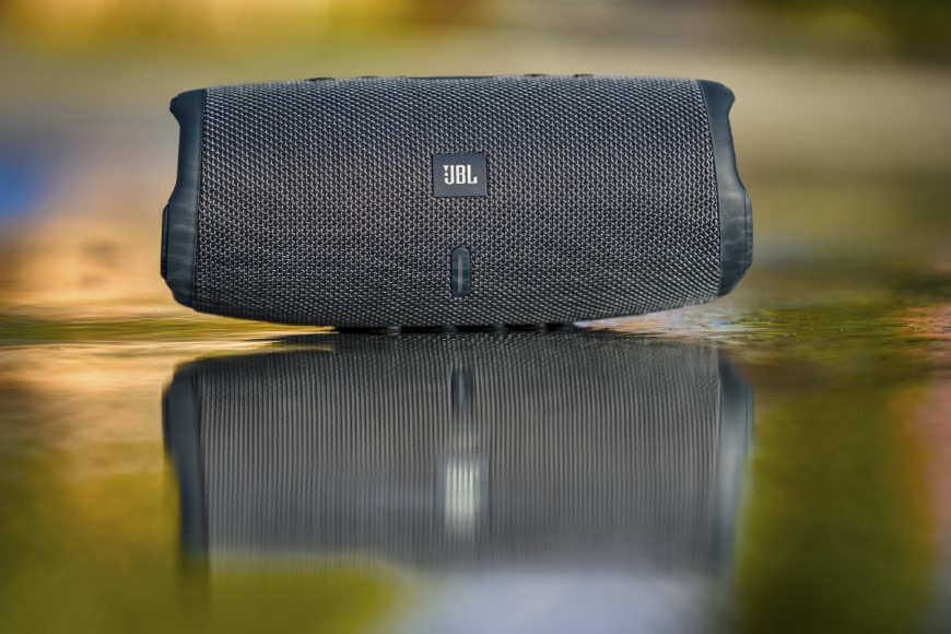 Odraz JBL Charge Essential 3 SE na mokré ploše symbolizuje vysokou odolnost reproduktoru proti vodě