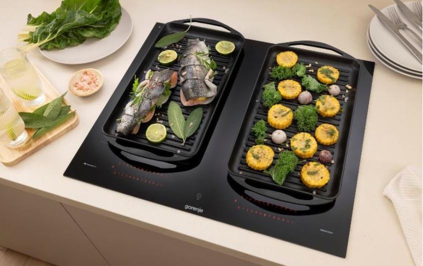 Indukční varná deska Gorenje G600 GI6442MSCWF InfiniteMatt černá Díky propojení varnych zon do jedne velke se na desce vari ve velkach nadobách. Na jedne strane je ryba a na druhe brambory.