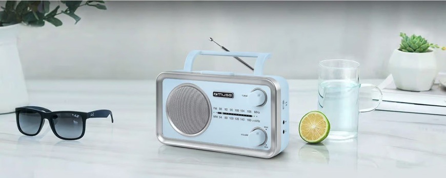 Radiopřijímač MUSE MF-060 modrý Radiopřijímač MUSE MF-060 VB v modrém provedení je položen na kuchyňské lince. Vedle něj jsou sluneční brýle a rozpůlená limetka s karafou vody.