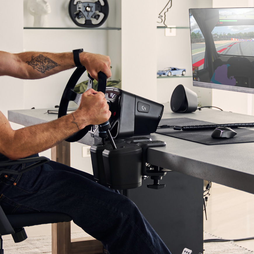 Logitech G RS Shifter & Handbrake upevněný ke stolu vedle závodního volantu