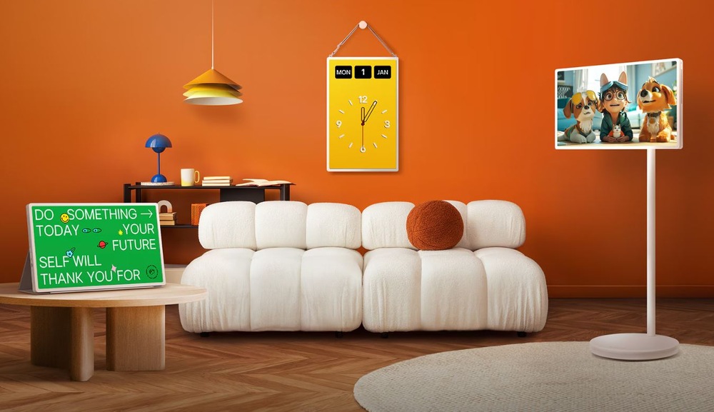 Televize LG 27LX6TDGA televize LG 27LX6TDGA umístěna v pokoji v terakotove barve. Je videt, jak lze televizi pouzivat. Visi na stěně jako žluté hodiny, stoji na stolku na tablet s podporou nebo muze stat na zemi díky stojánku